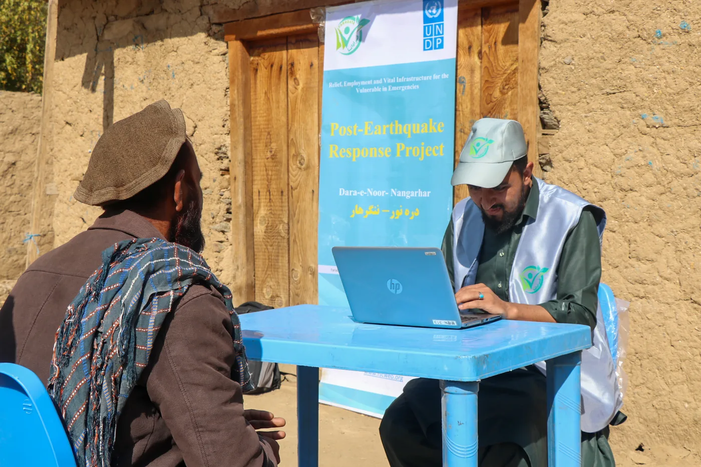 FSCWEO staff speak with a resident during a household survey in Dara-e-Noor